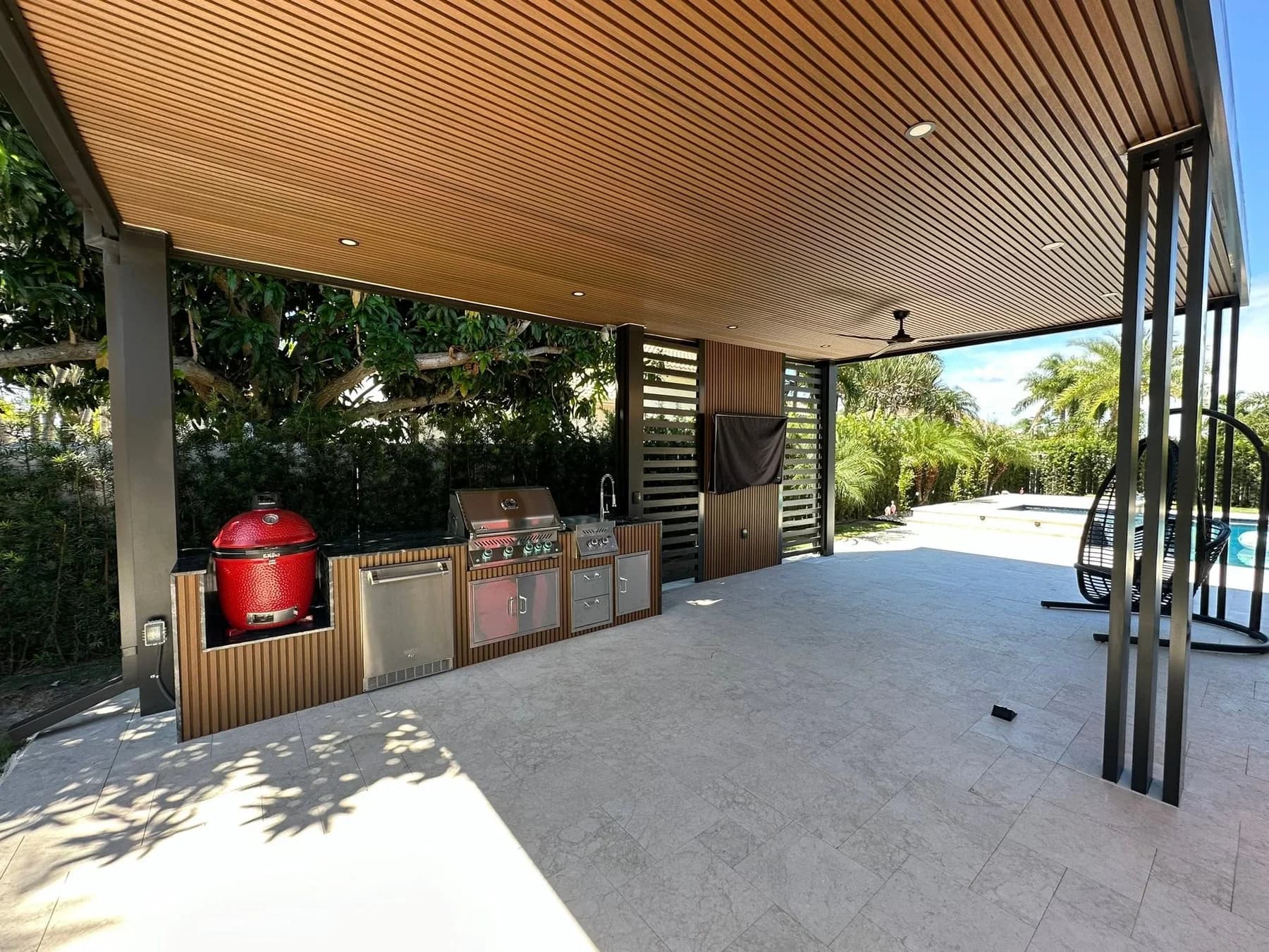 Finished covered outdoor cooking space with built-in grills and cabinetry